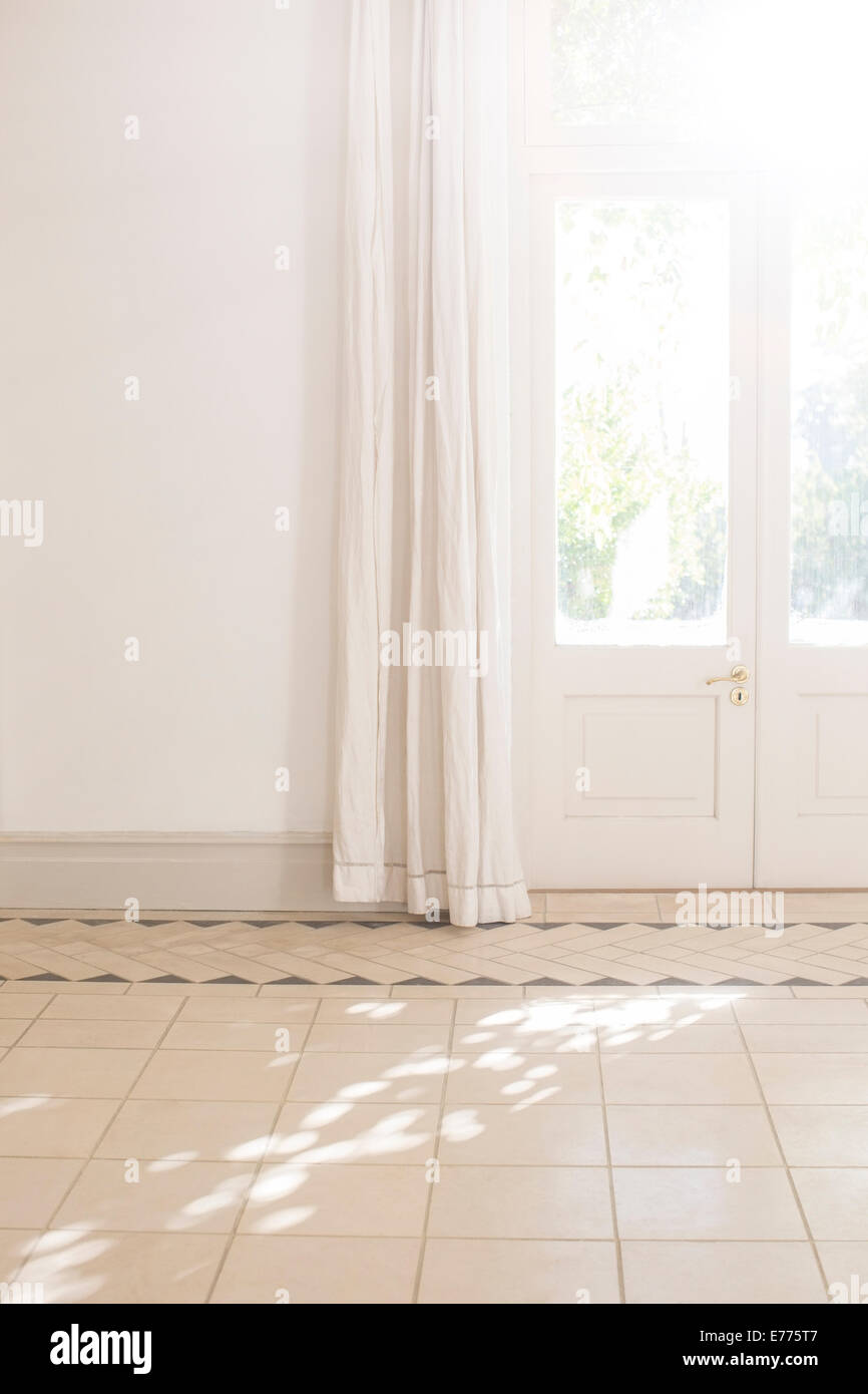 Transmission de la lumière du soleil à travers la fenêtre de la porte dans l'espace de vie Banque D'Images