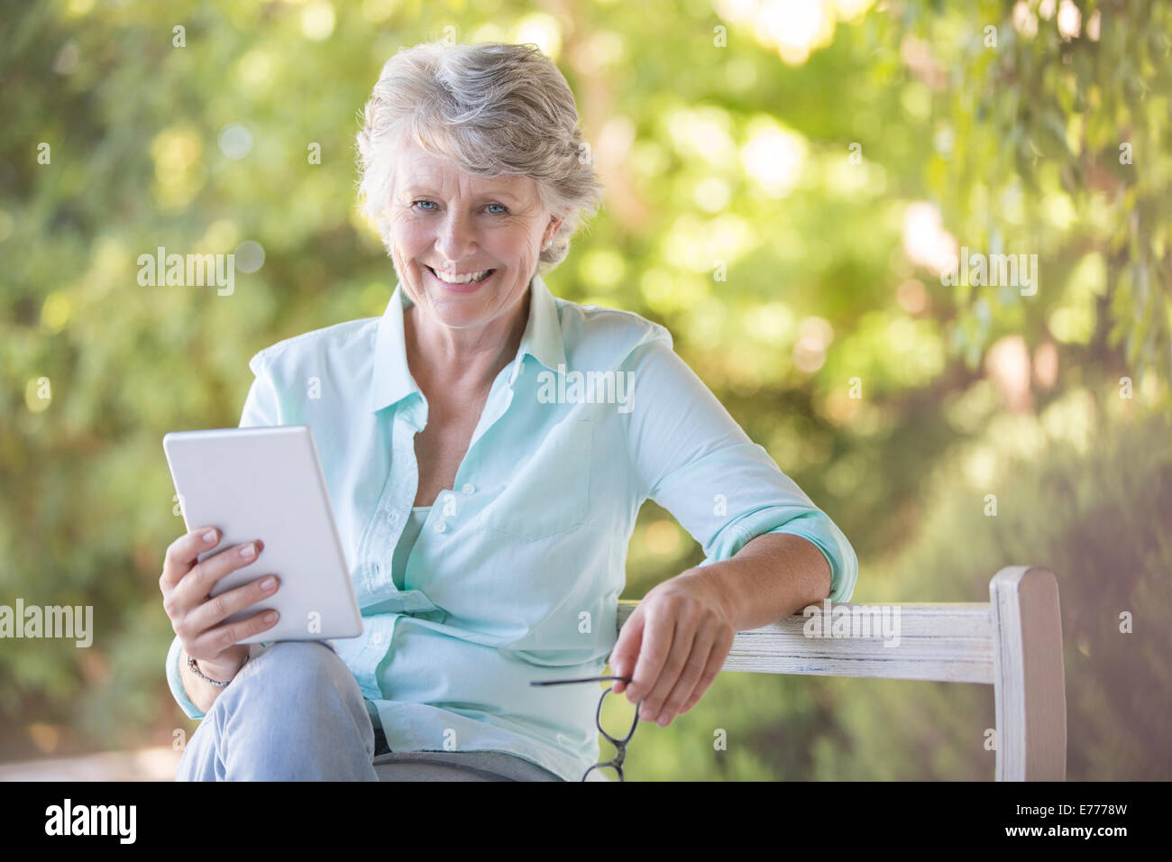 Older woman using digital tablet outdoors Banque D'Images