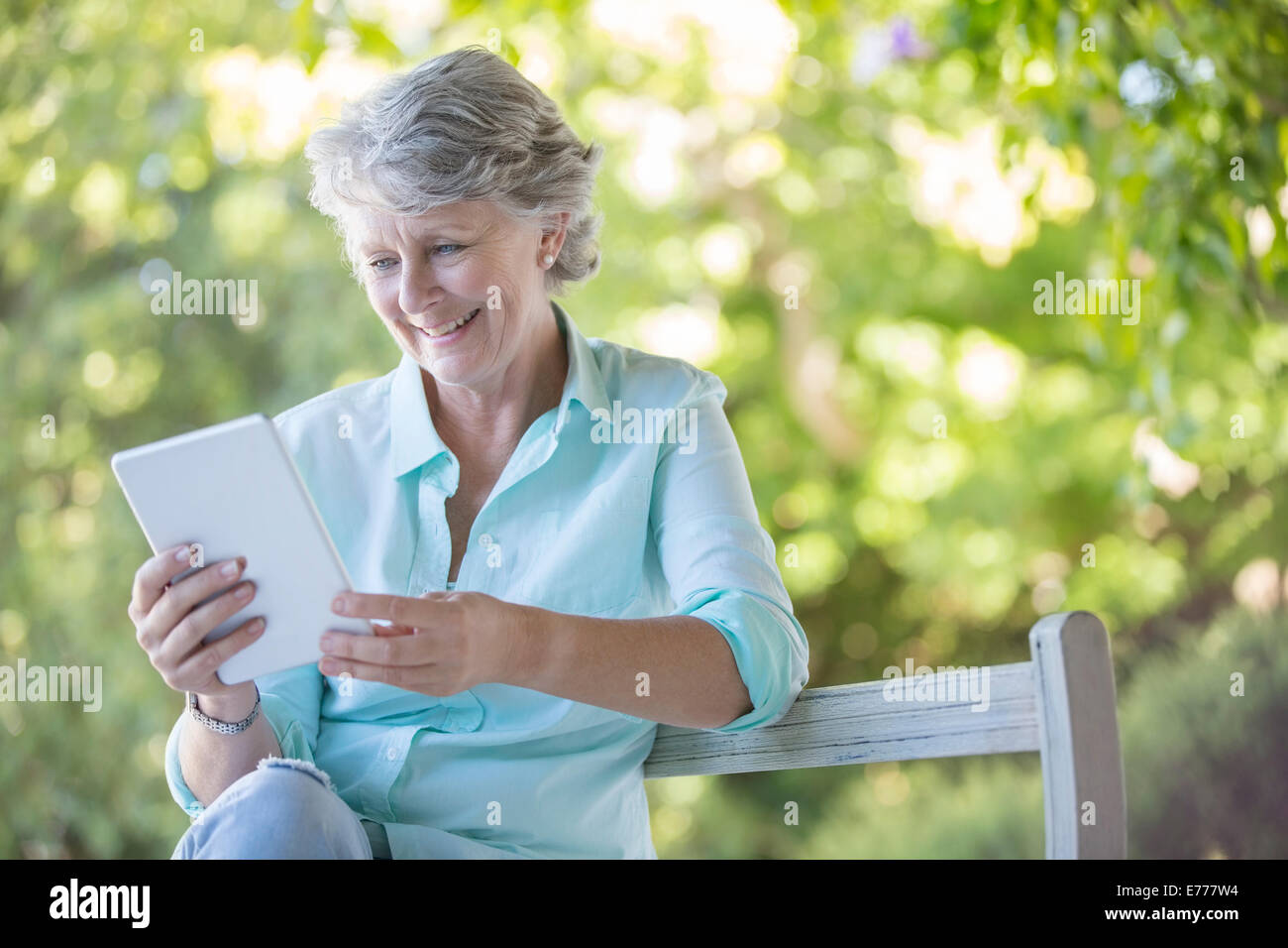 Older woman using digital tablet outdoors Banque D'Images