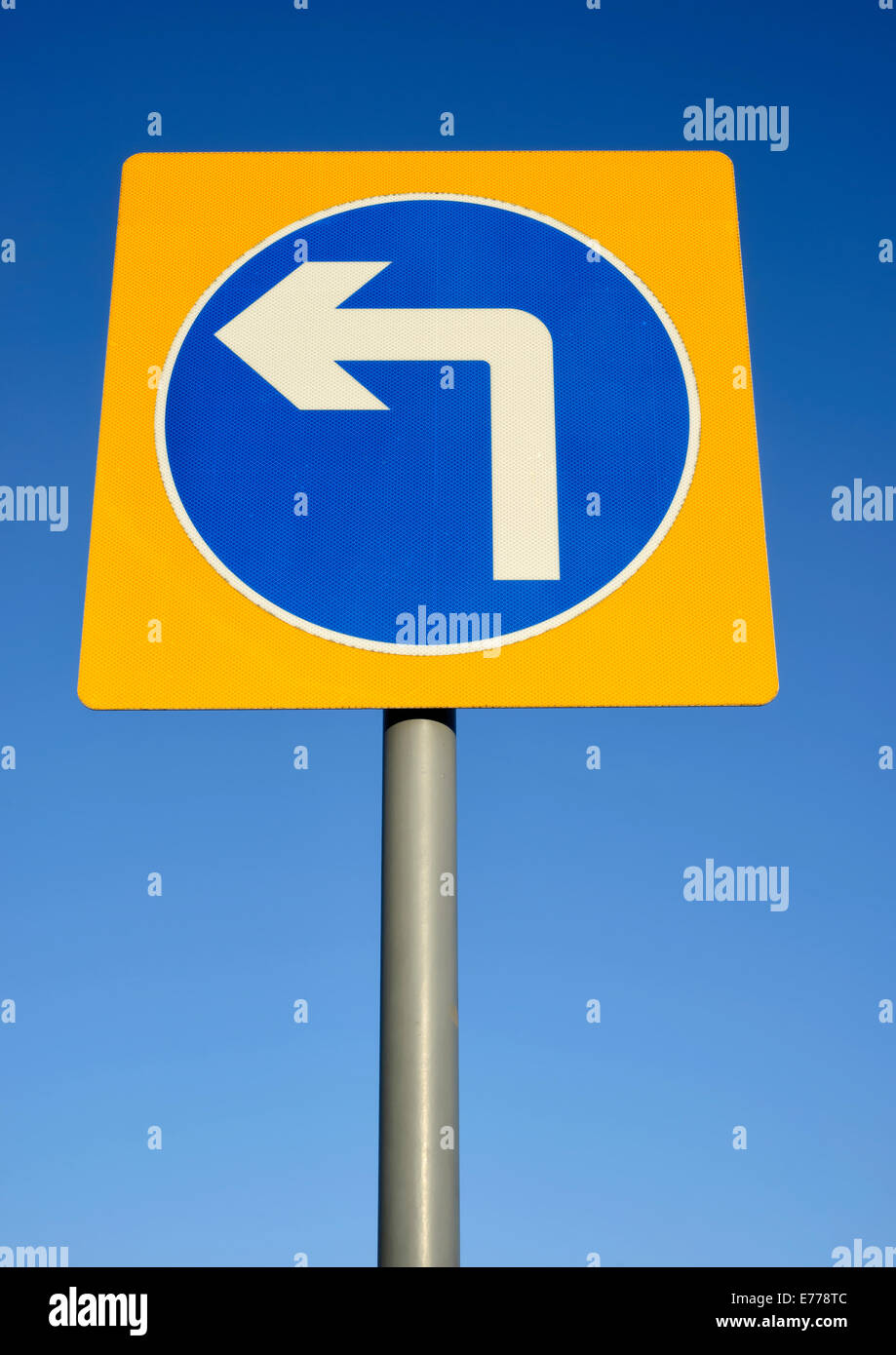 Tournez à gauche panneau routier set against a blue sky Banque D'Images