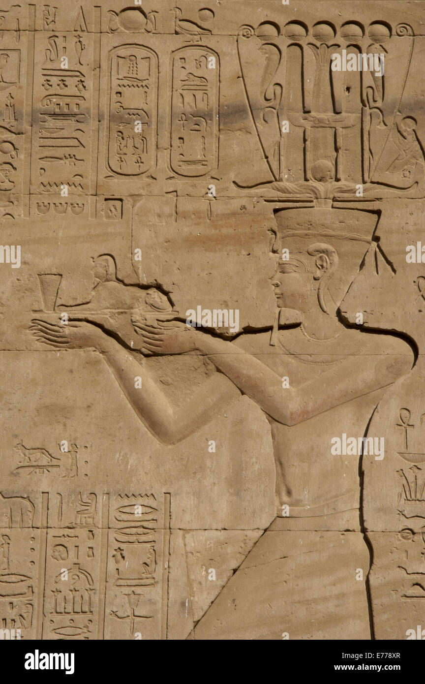 L'Égypte. Edfou. Temple d'Horus. Relief représentant un pharaon ptolémaïque offrande aux dieux d'un petit sphinx. Banque D'Images