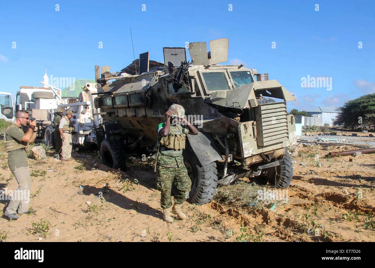 Mogadiscio. Sep 8, 2014. Vérifier les enquêteurs le site d'un carbomb suicide visant un convoi de la Mission de l'Union africaine en Somalie (AMISOM) sur une route reliant Mogadiscio et Afgooye, une petite ville à 20 km à l'ouest de la capitale, le 8 septembre 2014. Le groupe islamiste Al-Shabaab le lundi a revendiqué la responsabilité des attentats-suicide à la voiture 1 qui a tué au moins 12 personnes en Somalie, selon des sources policières. L'autre carbomb suicide blast a frappé un poste de contrôle militaire à la périphérie de Mogadiscio le lundi, blessant deux personnes dont un fonctionnaire local. Credit : Faisal Miu/Xinhua/Alamy Live News Banque D'Images