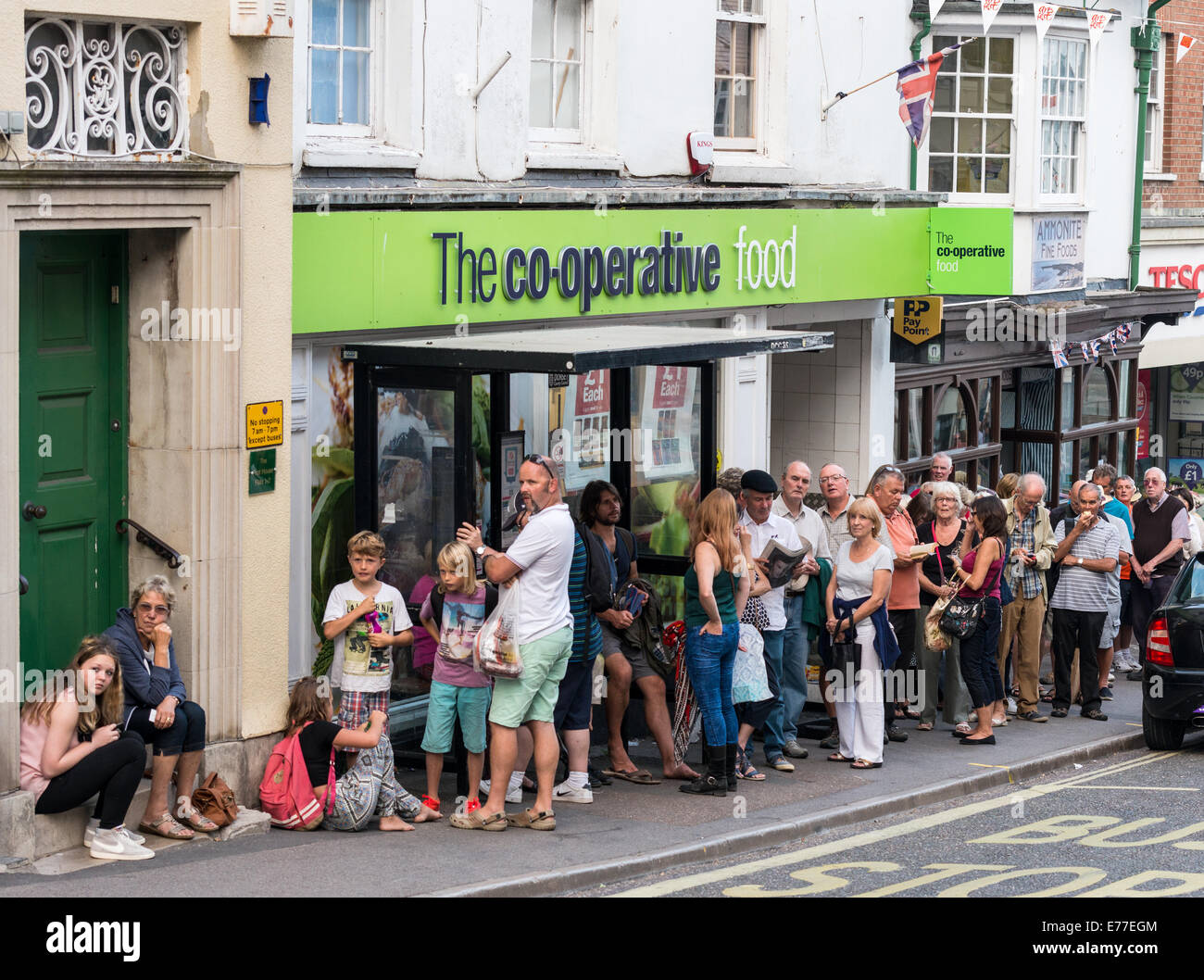 Une longue file de gens qui attendaient pour le Park & Ride à venir et de les transporter à leurs véhicules à Lyme Regis, dans le Dorset. Banque D'Images