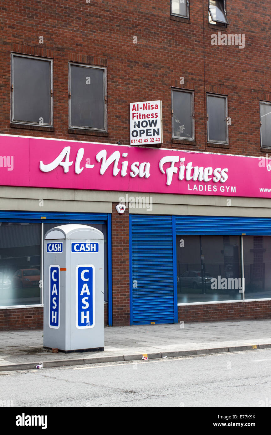 Un distributeur automatique de billets prise dans une cabine téléphonique à l'extérieur de remise en forme Al-Nisa Attercliffe Sheffield England UK Banque D'Images