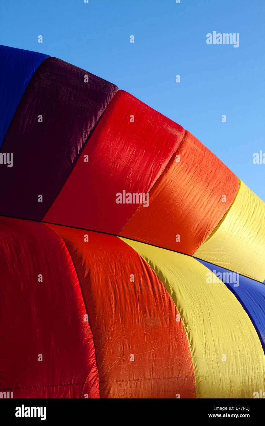 Détail d'un ballon à air chaud d'être gonflées dans early morning light against a blue sky Banque D'Images