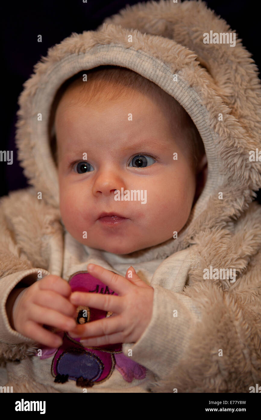 Baby girl, 2 mois, portant un costume en fausse fourrure Banque D'Images