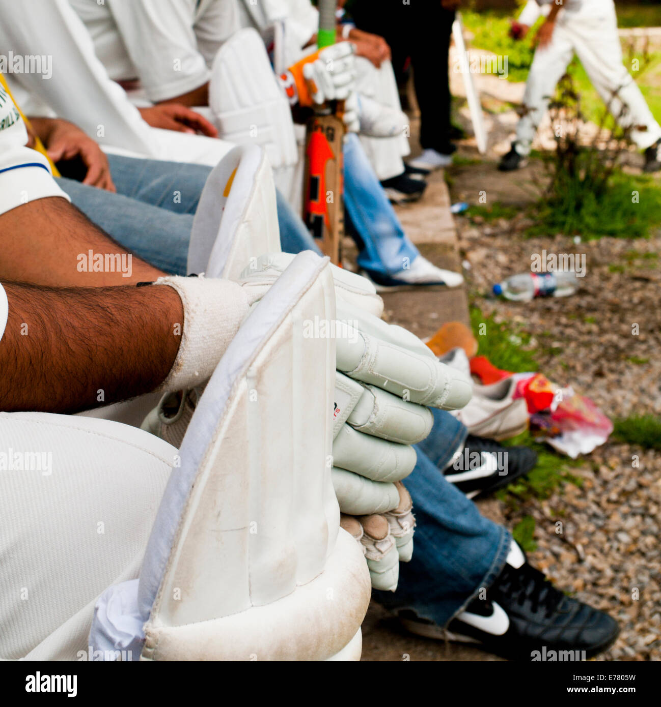 Batteurs asiatique assis en attente de rendez-vous au cours d'un match de cricket en Banque D'Images