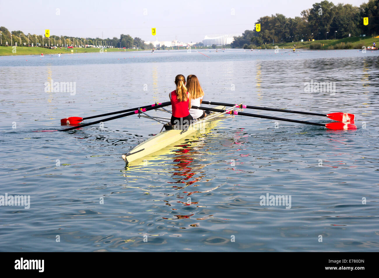 Deux jeunes filles dans un bateau, les palettes sur le paisible lac Banque D'Images