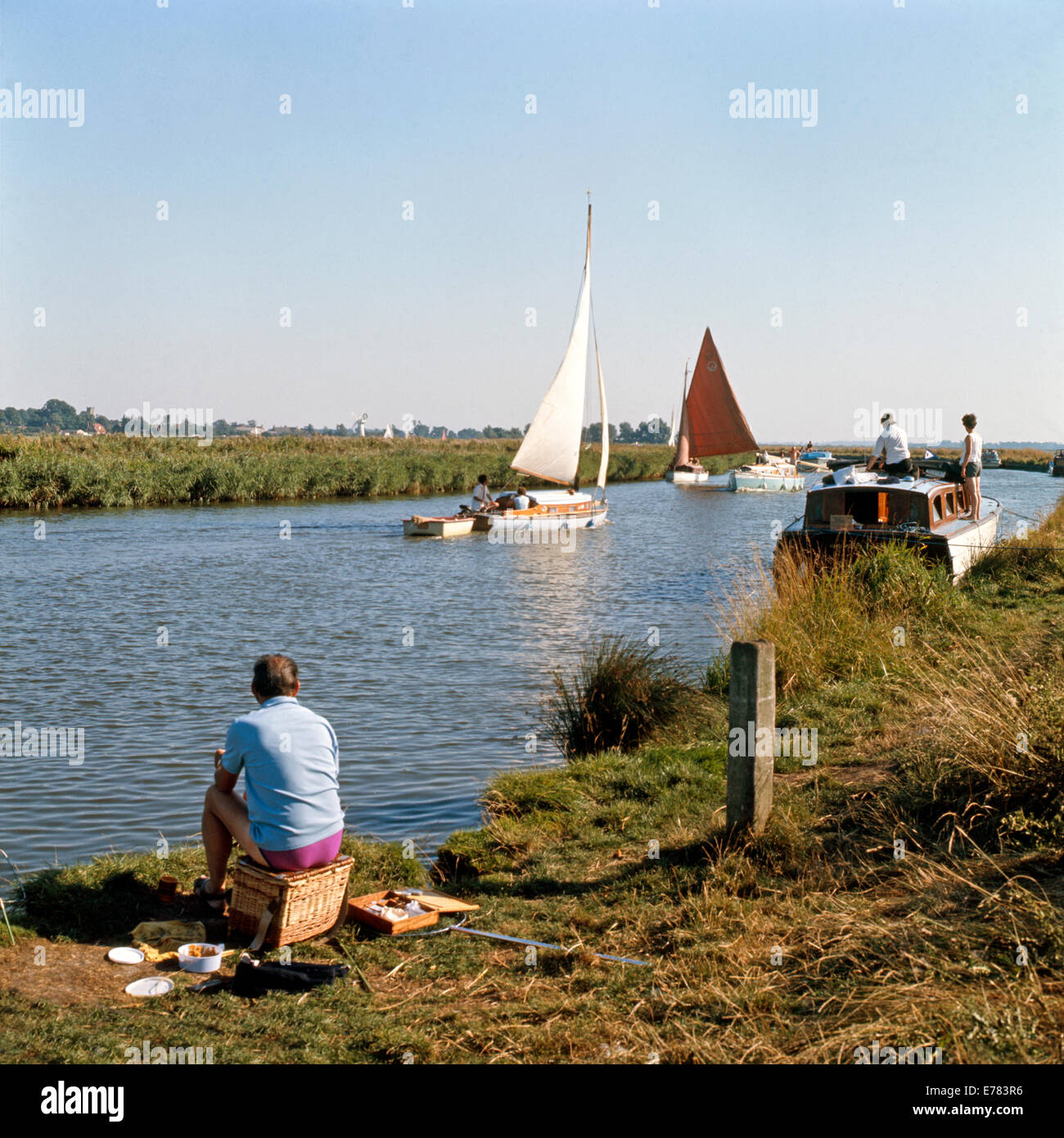 La pêche sur l'homme de la rivière Thurne, Norfolk, avec des bateaux au-delà Banque D'Images