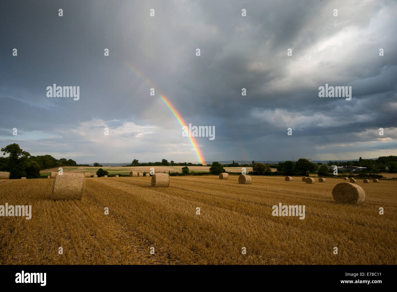 Lumière du soir orageux et un arc-en-ciel dans un champ de bottes de foin, Stanton par Dale dans le Derbyshire Banque D'Images