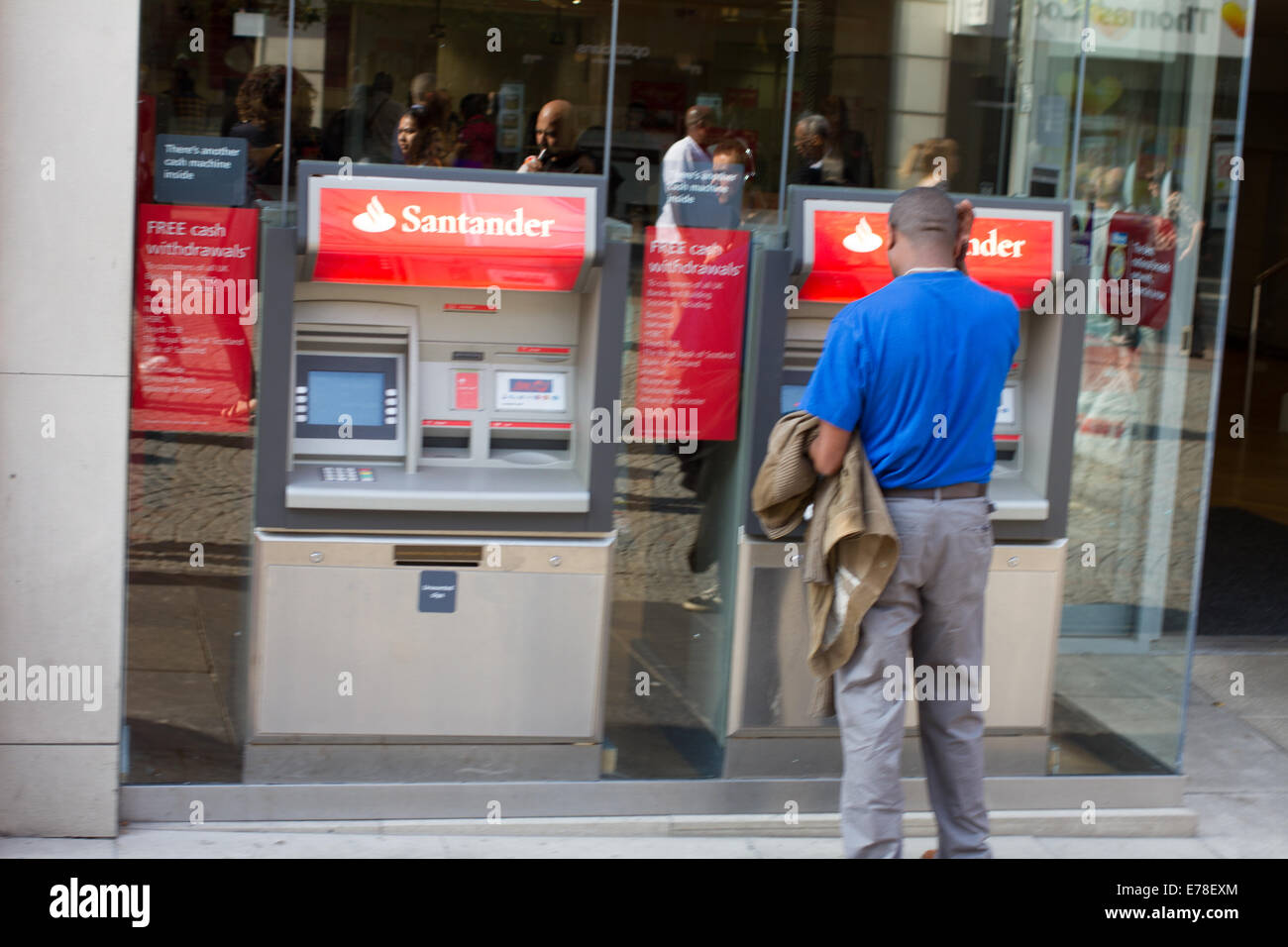 Un homme à l'aide d'une machine à cash de Santander à Sheffield UK Banque D'Images