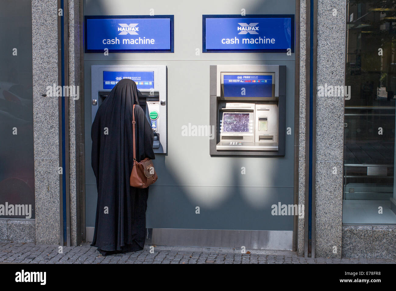 Une femme dans une burqa à l'aide d'une machine à cash d'Halifax Banque D'Images
