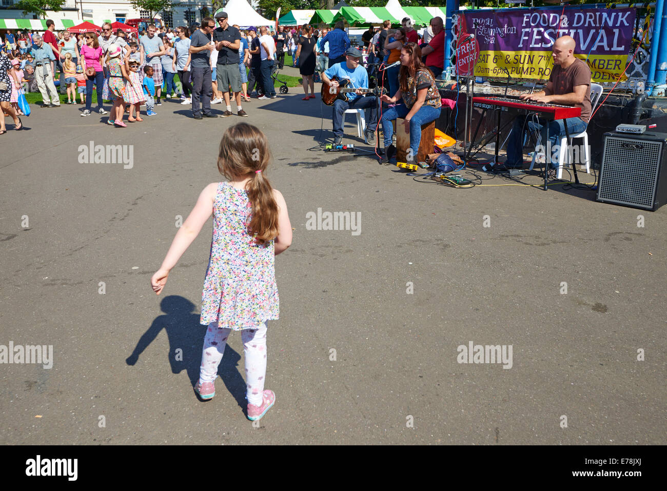 Jeune fille danse à la musique joué par l'Jazulu Jazz Trio à la nourriture et les boissons Festival Leamington Spa Warwickshire UK Banque D'Images