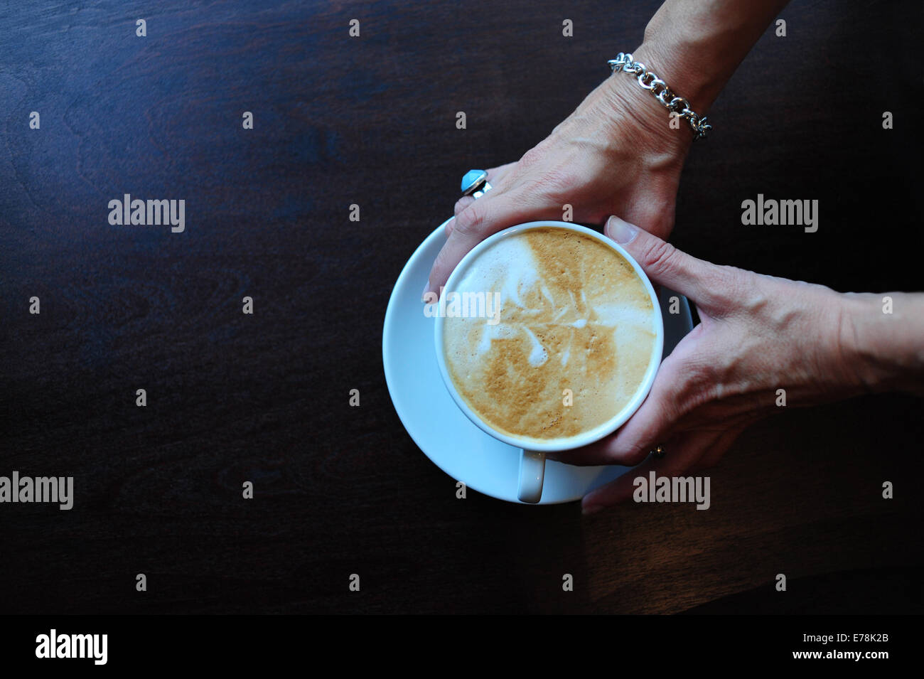 Mature Woman in cafe tenant une tasse de café cappuccino Banque D'Images
