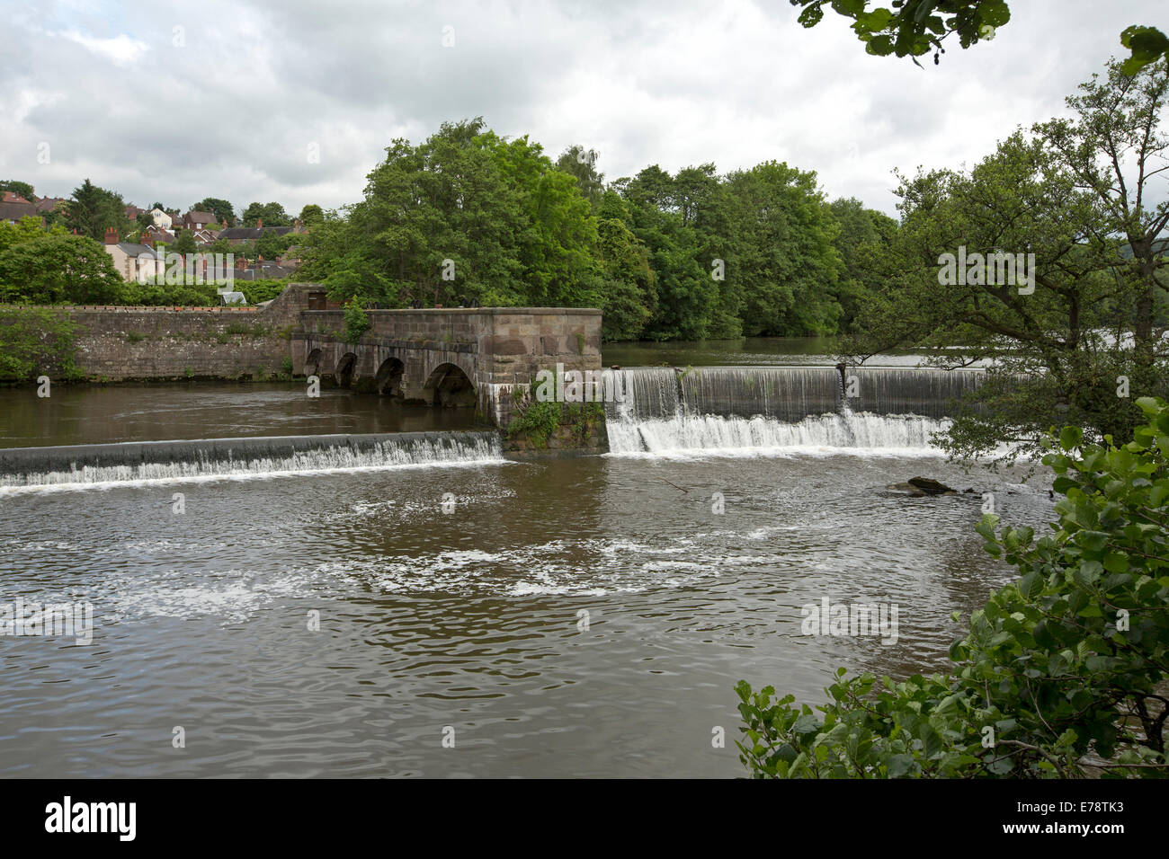 Derwent River se répandre au déversoir en forme de fer à cheval au village anglais de Belper avec rivière arbres se reflétant dans l'eau calme Banque D'Images