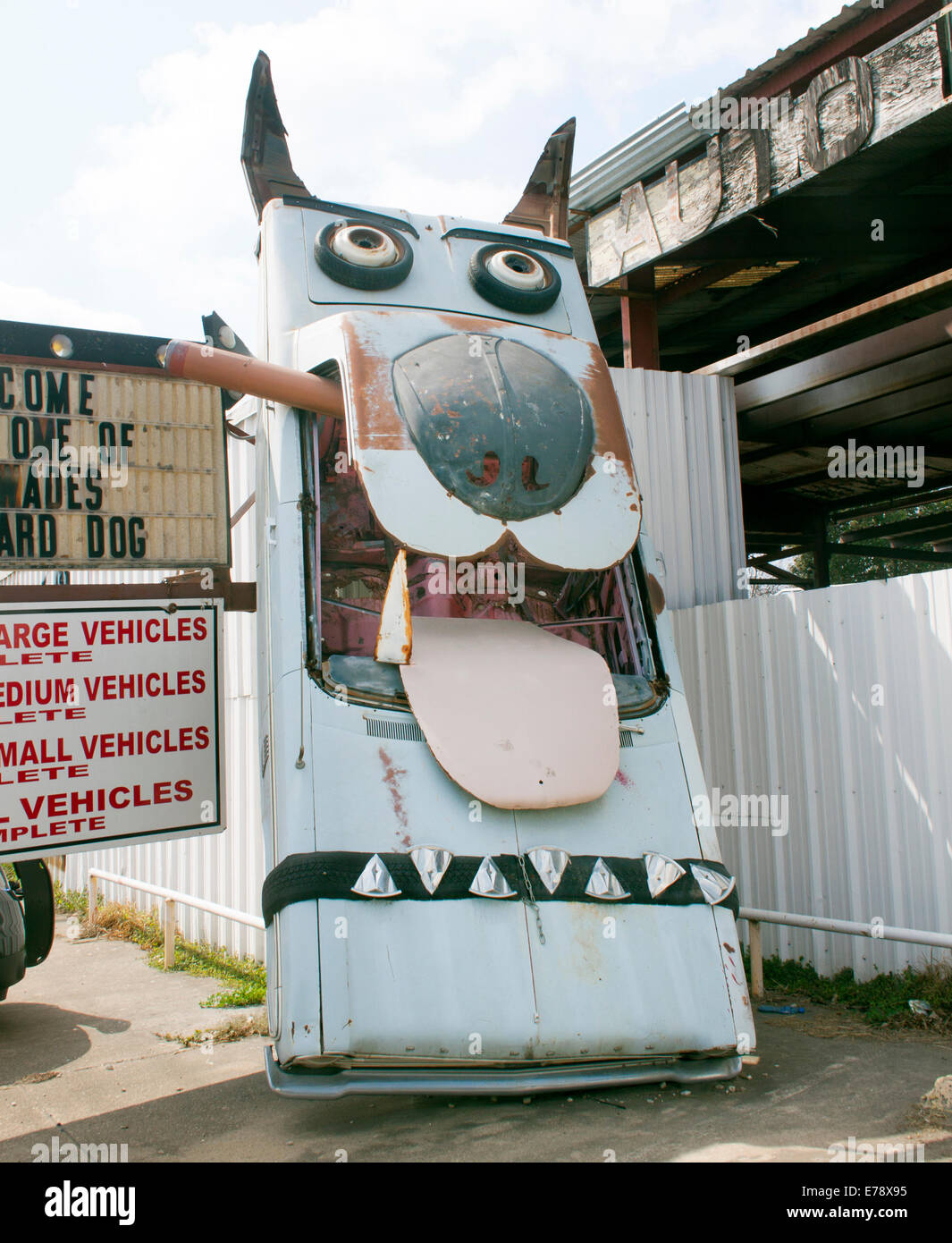 Une sculpture de voiture ludique en forme de chien devant un garage à San Antonio, Texas, ajoute une dose d'humour et de créativité au paysage de bord de route. Banque D'Images