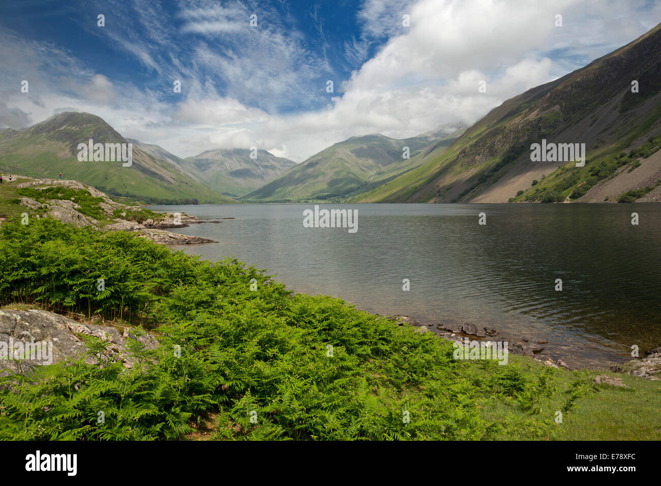 Lac Wastwater entourée de sommets de montagnes recouvertes de végétation verte, ciel bleu avec des nuages bas, Lake District, Cumbria England Banque D'Images