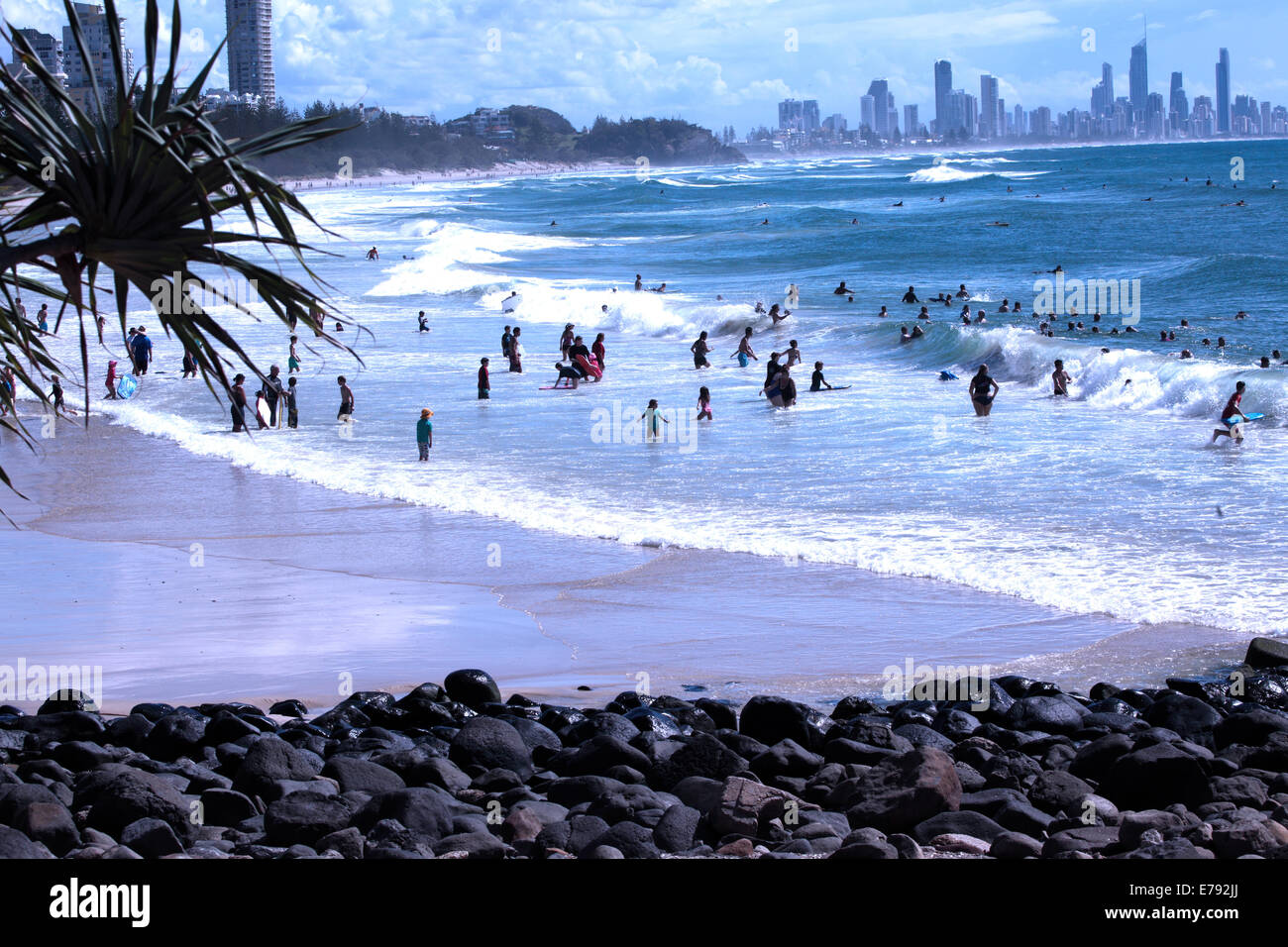 Surfers appréciant les vagues à Burleigh Heads sur la Gold Coast en Australie.Surfers Paradise se trouve dans la distance. Banque D'Images