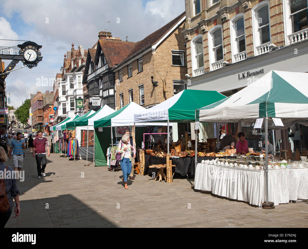 Les gens de shopping dans la rue piétonne animée avec les étals de marché à Winchester, Hampshire, Angleterre Banque D'Images