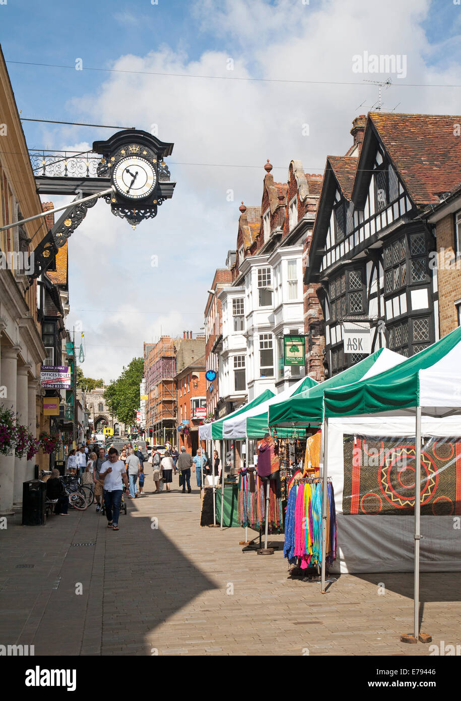 Les gens de shopping dans la rue piétonne animée avec les étals de marché à Winchester, Hampshire, Angleterre Banque D'Images