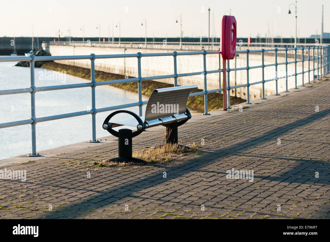 Banc public vide sur Harbour Front sur soirée ensoleillée Banque D'Images