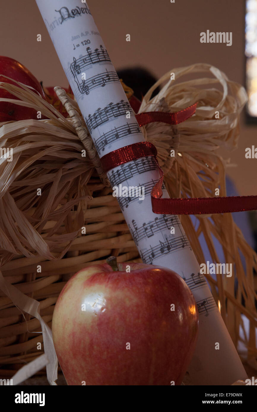 Apple et rouleaux de feuilles de musique, à côté d'un panier de paille Banque D'Images