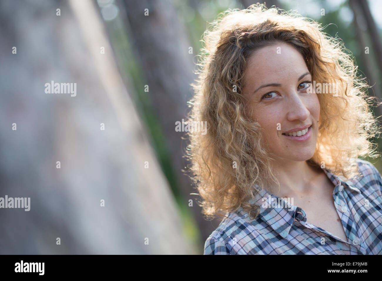 Une femme marche dans l'ombre des arbres au bord d'un lac. Banque D'Images