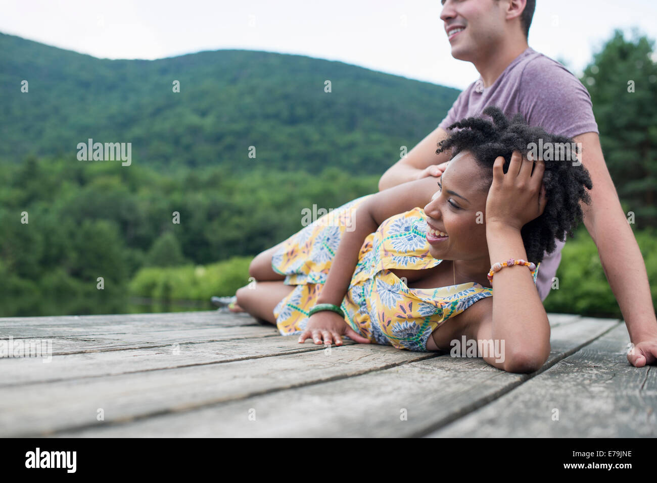 Un couple de détente sur une jetée donnant sur un lac de montagne. Banque D'Images
