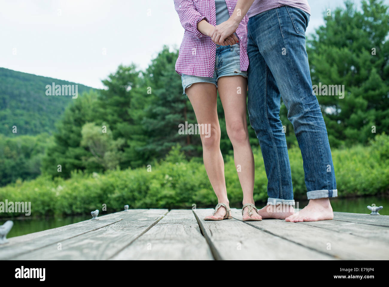 Un couple sur une jetée en bois par un lac. Banque D'Images