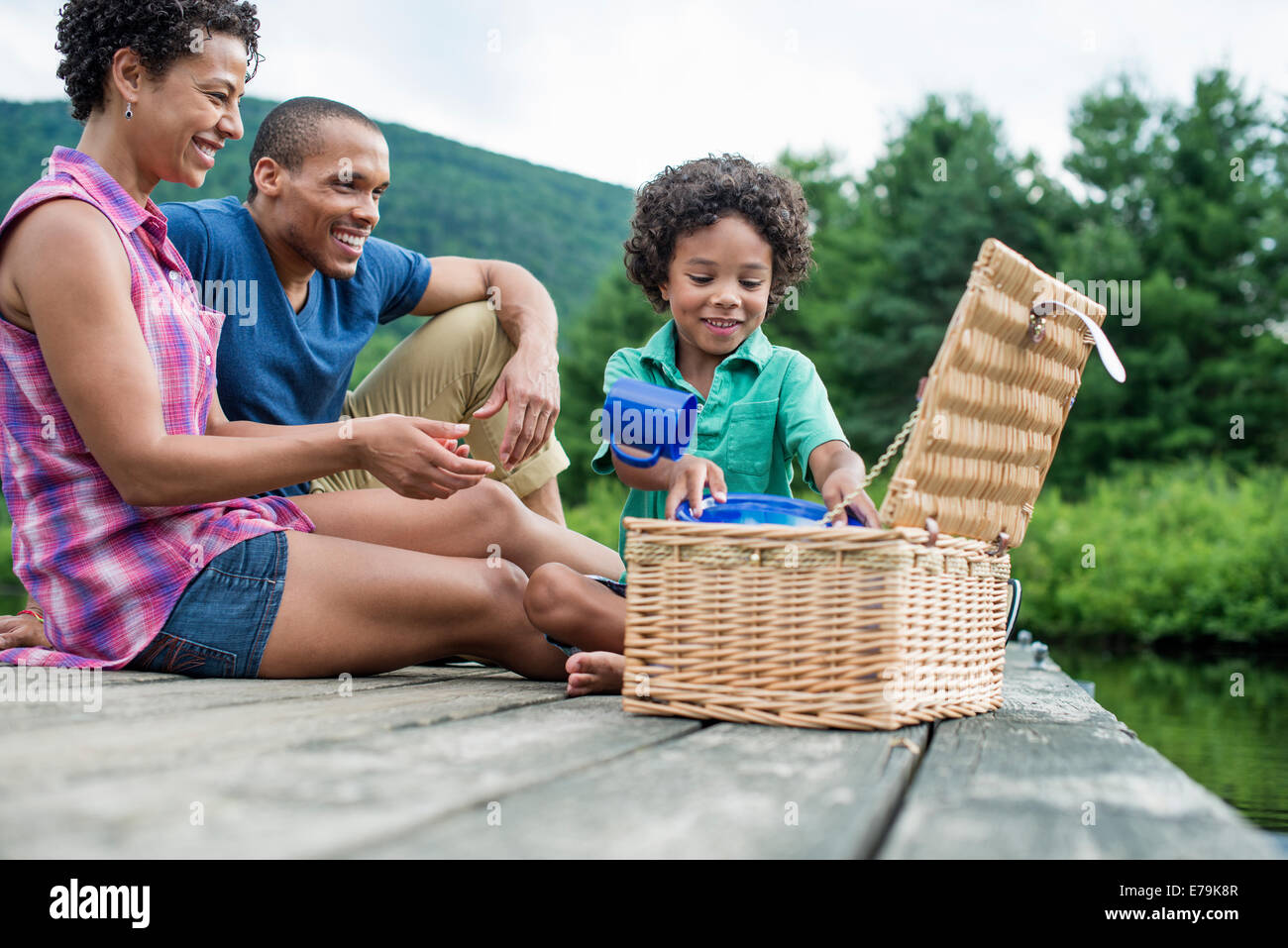 Une famille ayant un pique-nique d'été au bord d'un lac. Banque D'Images