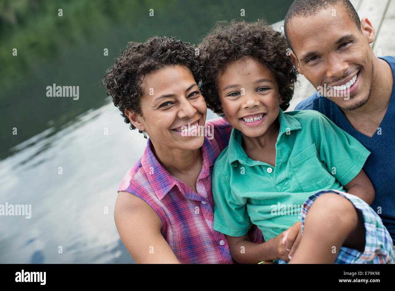 Une famille, les parents et un jeune garçon, d'un lac en été. Banque D'Images