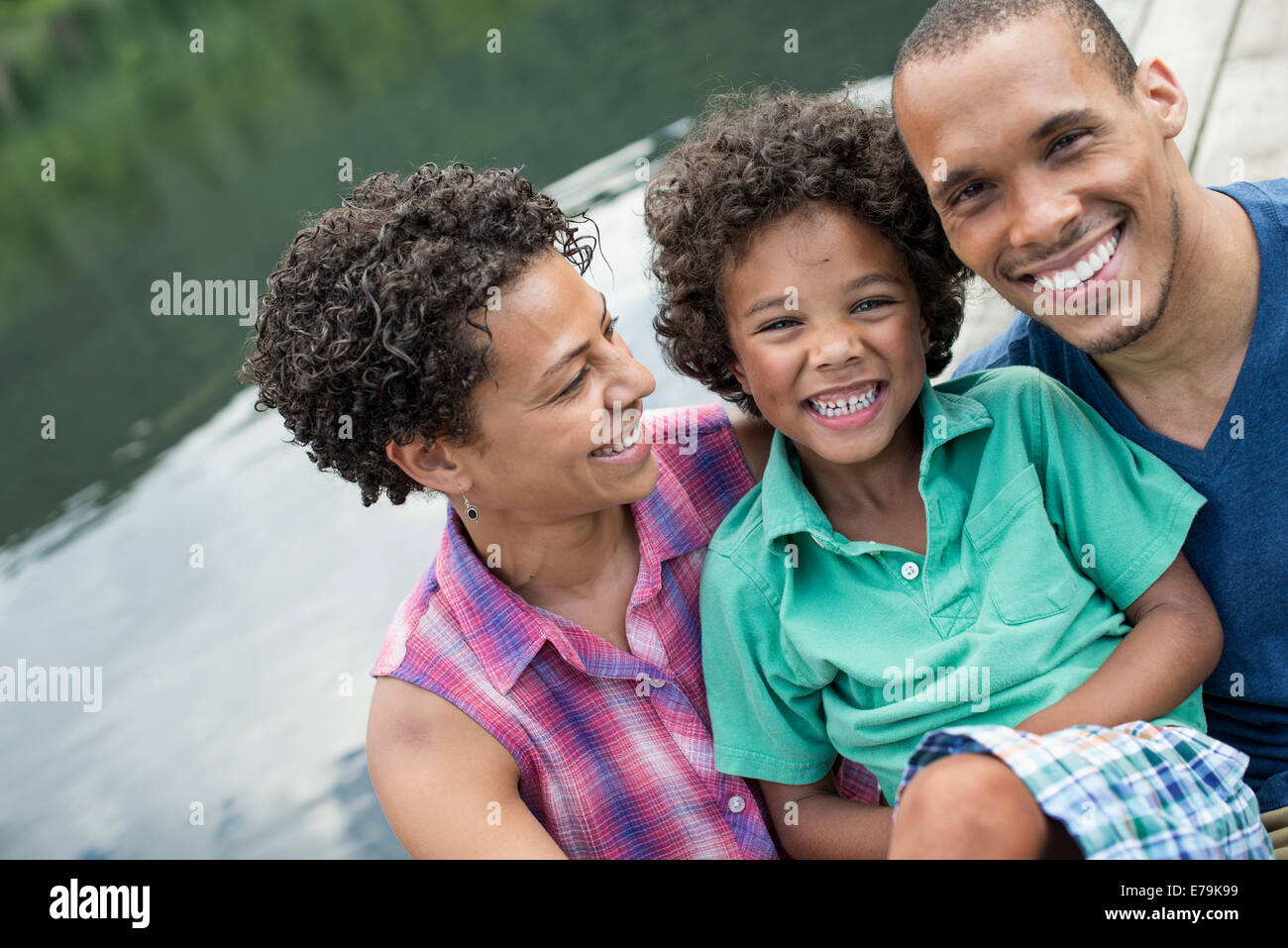Une famille, les parents et un jeune garçon, d'un lac en été. Banque D'Images