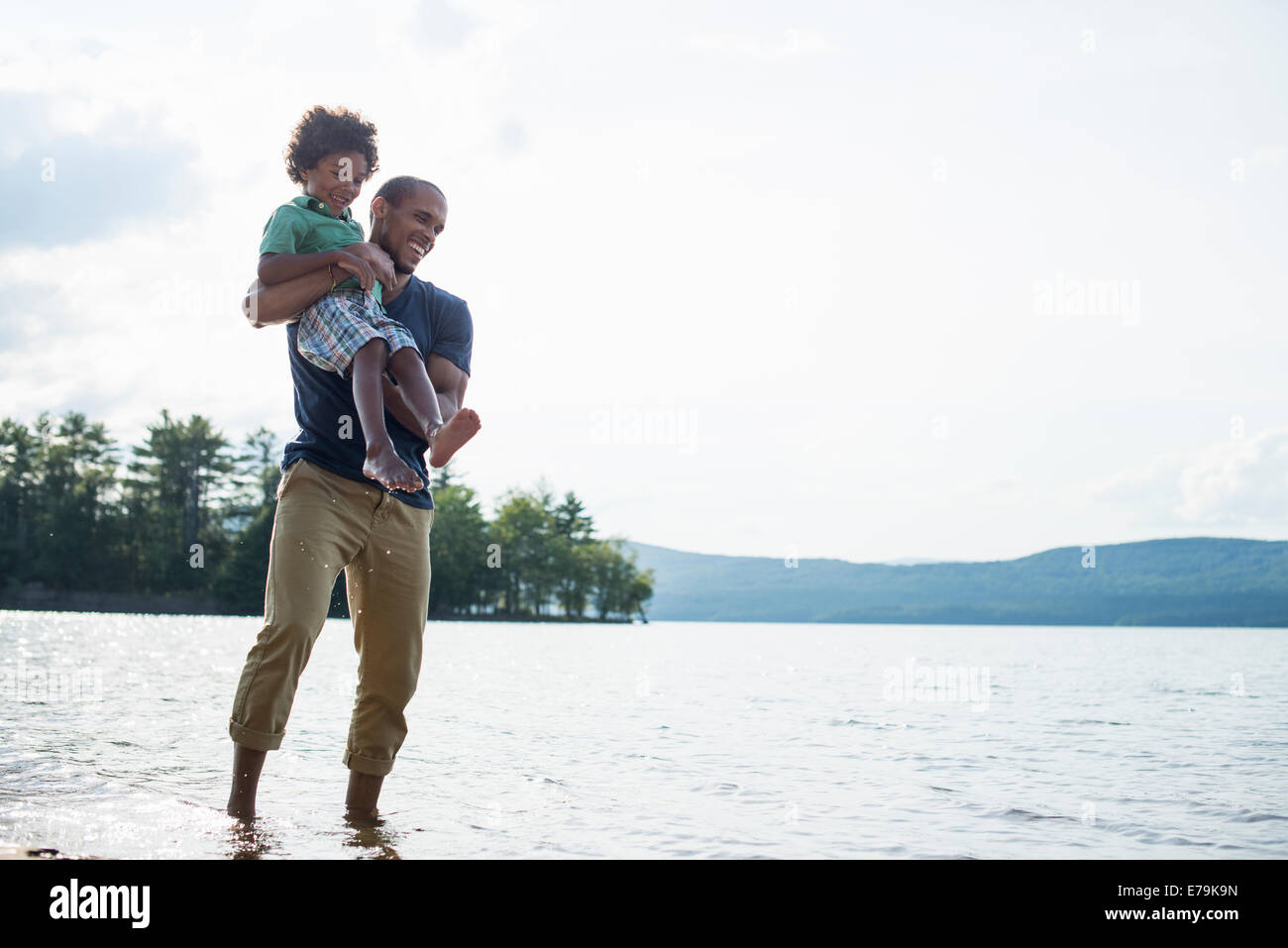 Un père et son fils, sur une rive du lac en été. Banque D'Images