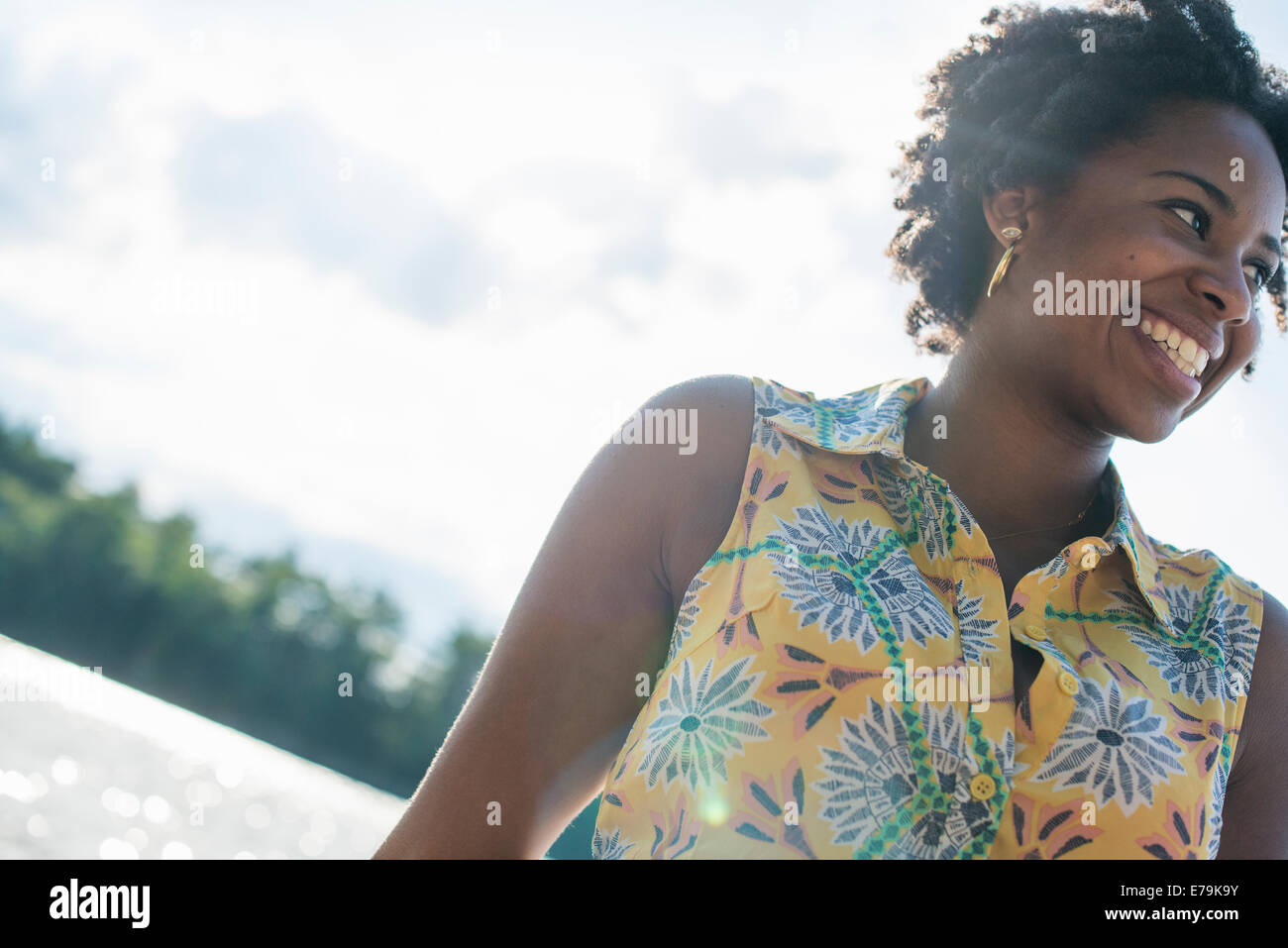 Une femme sourire et rire sur une rive du lac. Banque D'Images