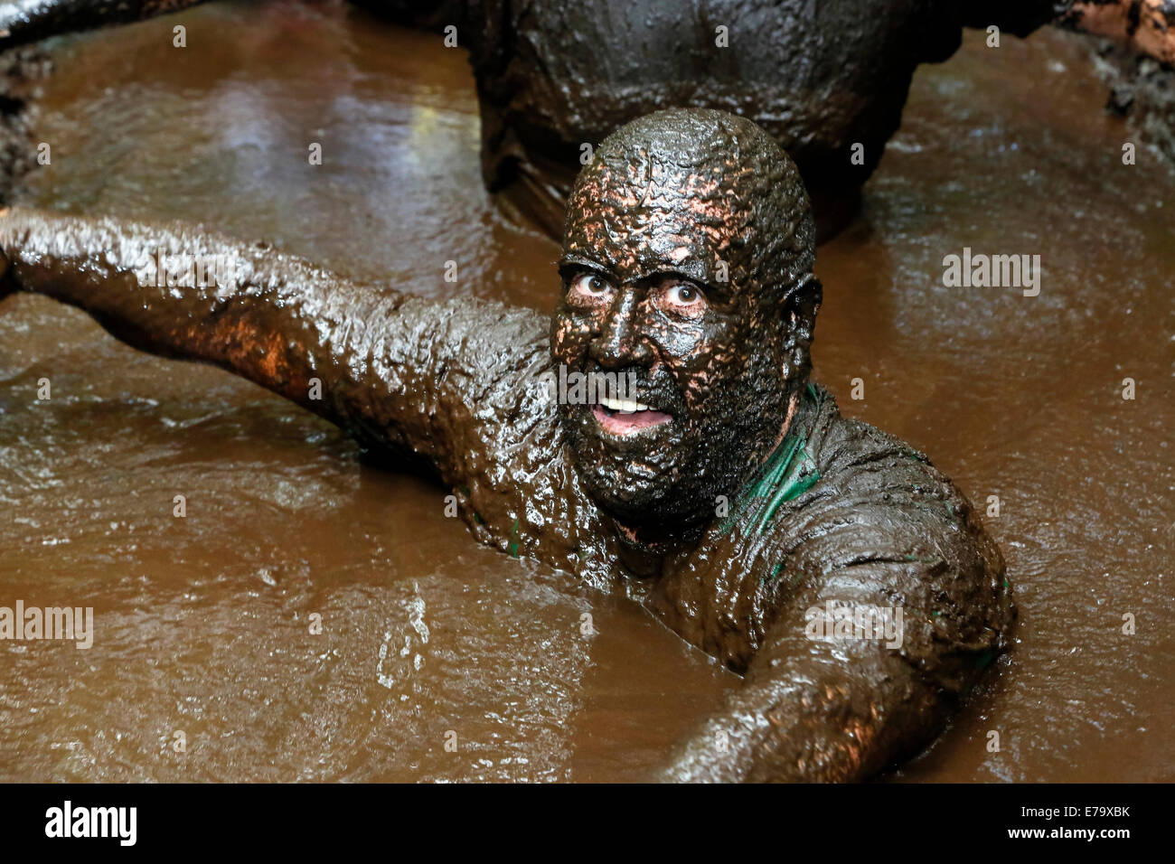 L'homme couvert de boue et qui a pris part à un concours de boue Runner, Kilmarnock, Ayrshire, Scotland, UK Banque D'Images