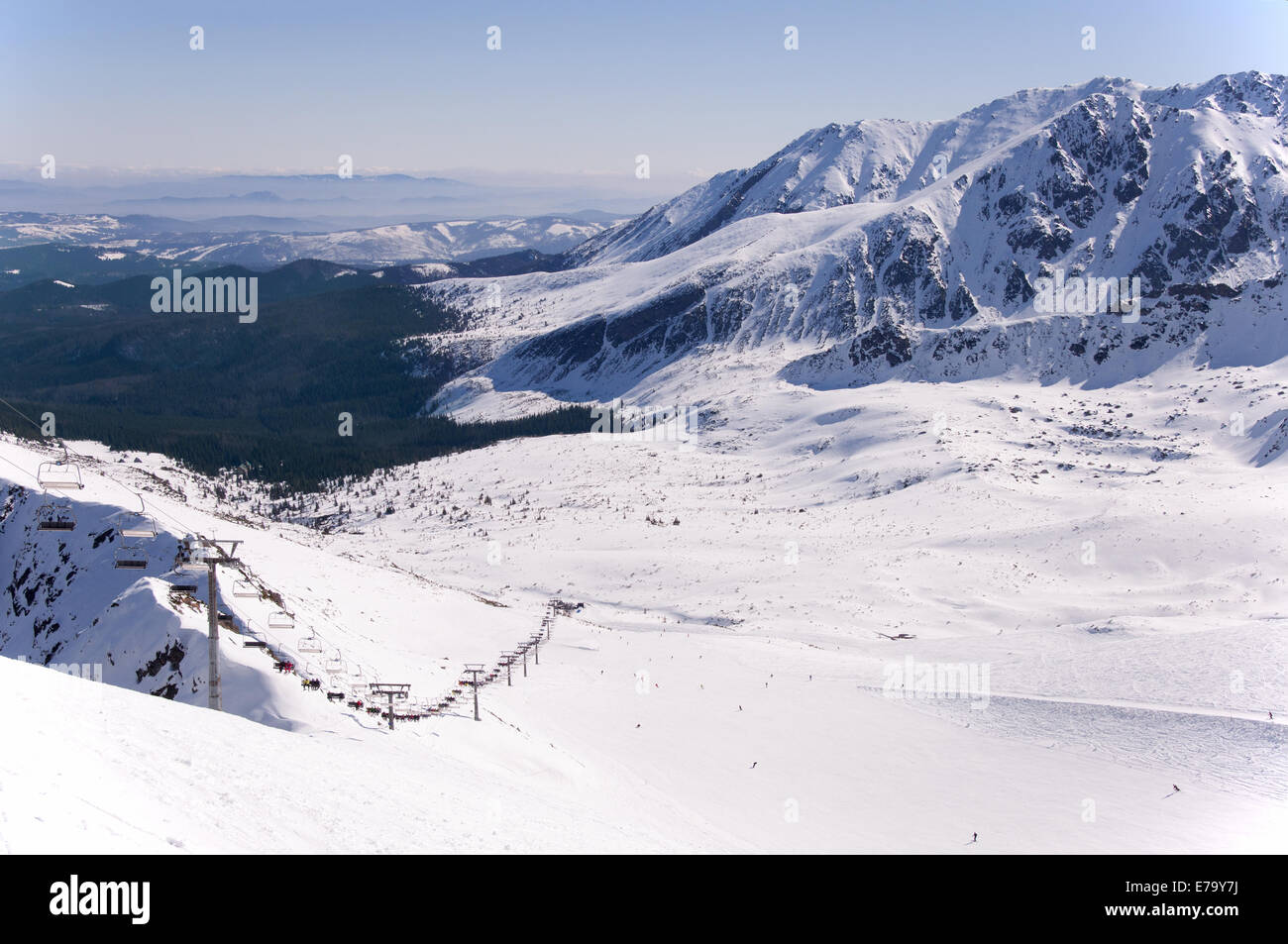 Pistes de ski et télésiège sur Hala Gąsienicowa dans Tatras en Pologne avec l'extrême vue de la région de Podhale. Banque D'Images