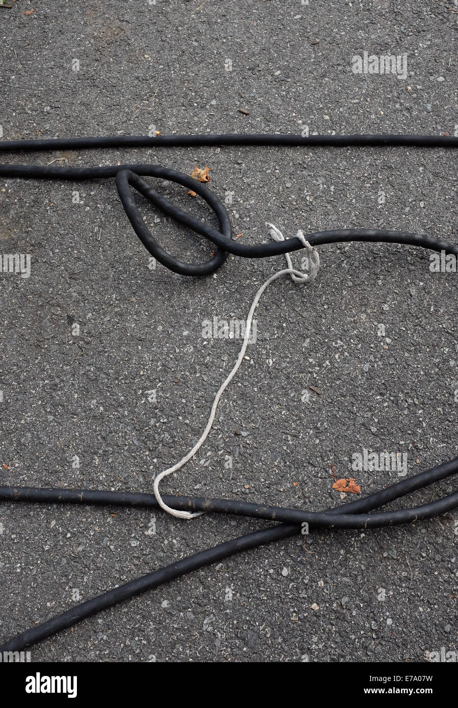 Câble noir et blanc corde sur l'Asphalte Banque D'Images