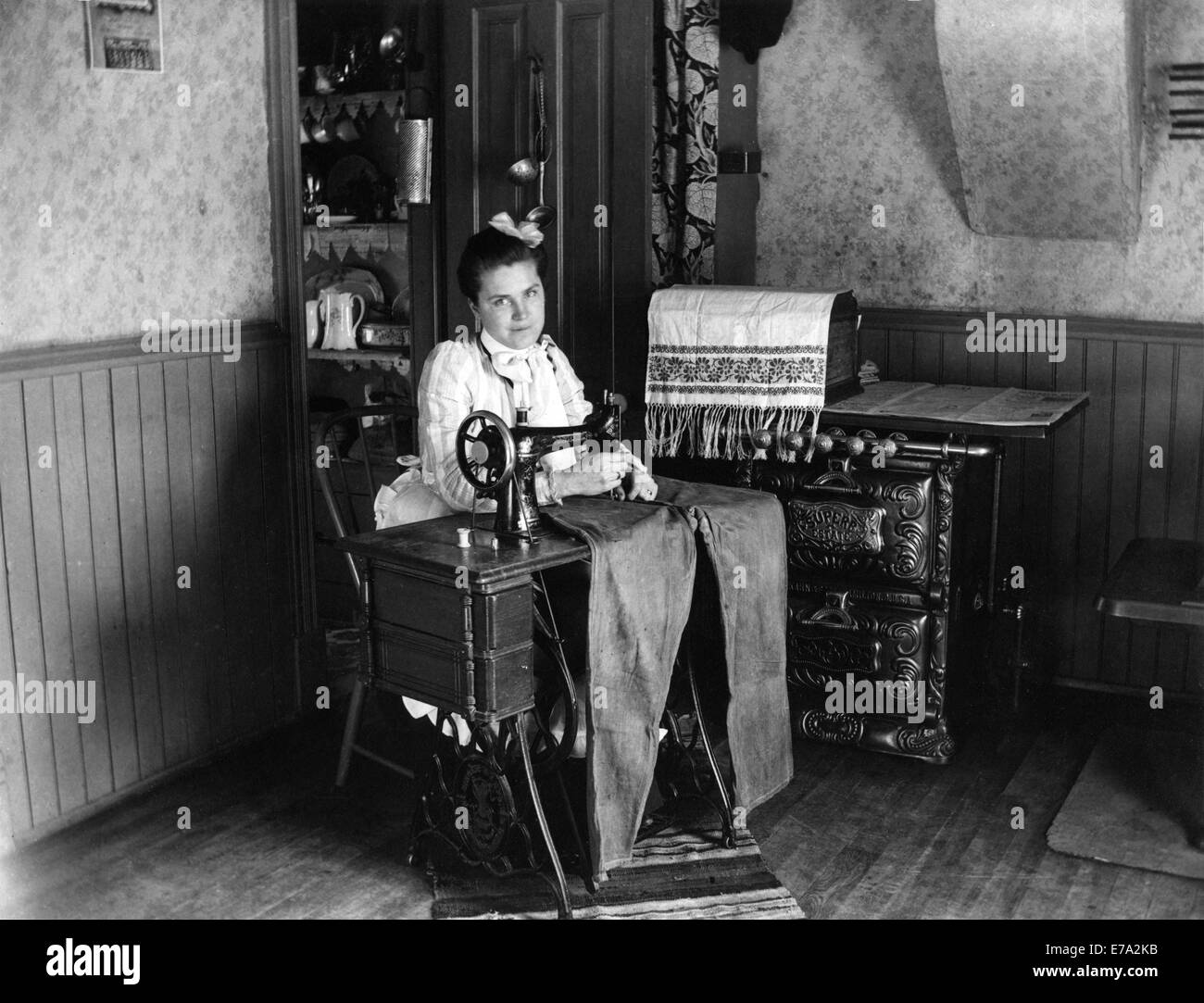 Couture femme pantalon sur machine à coudre, vers 1905 Banque D'Images