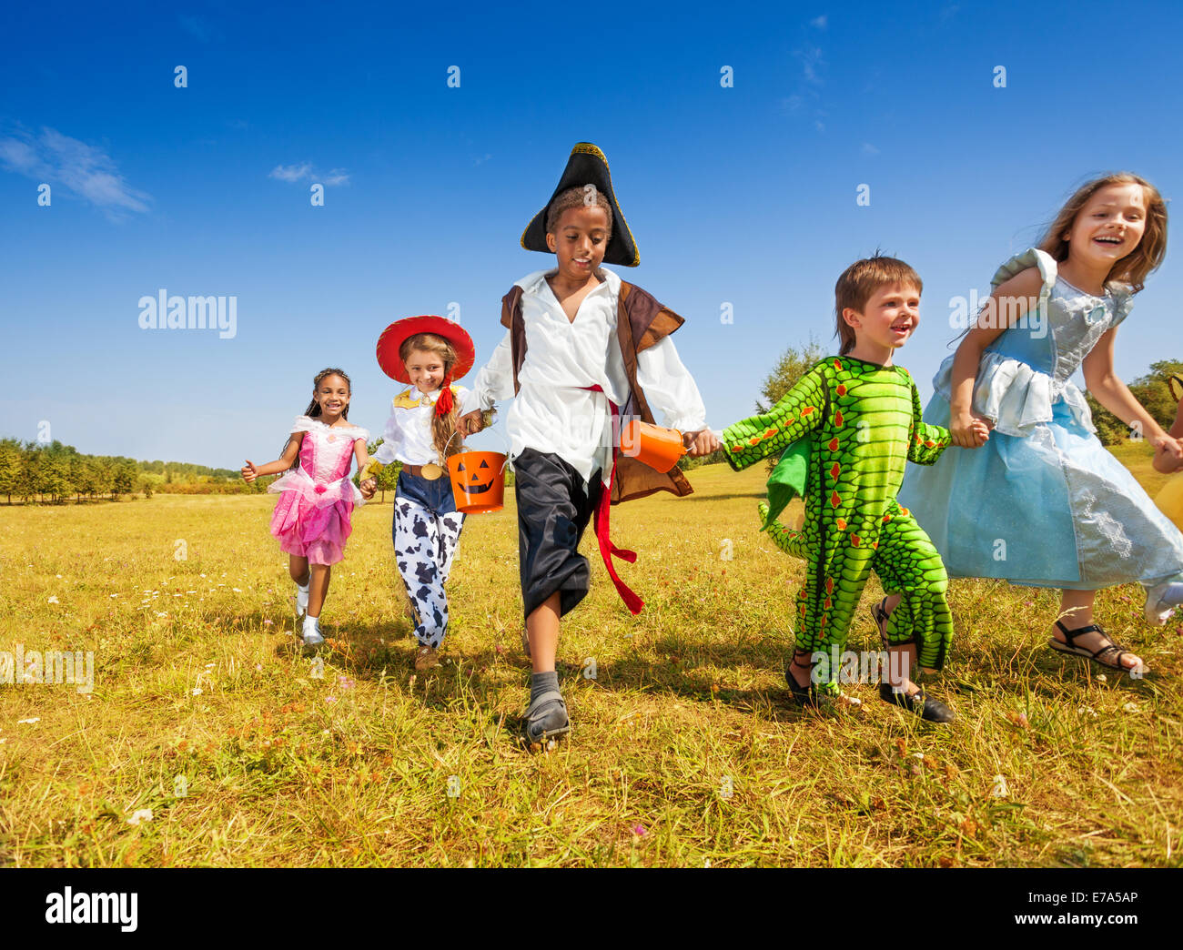 Groupe d'enfants avec des costumes running in park Banque D'Images
