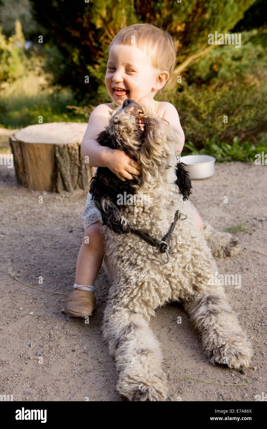 Petite fille jouant avec un chien d'eau Portugais Banque D'Images