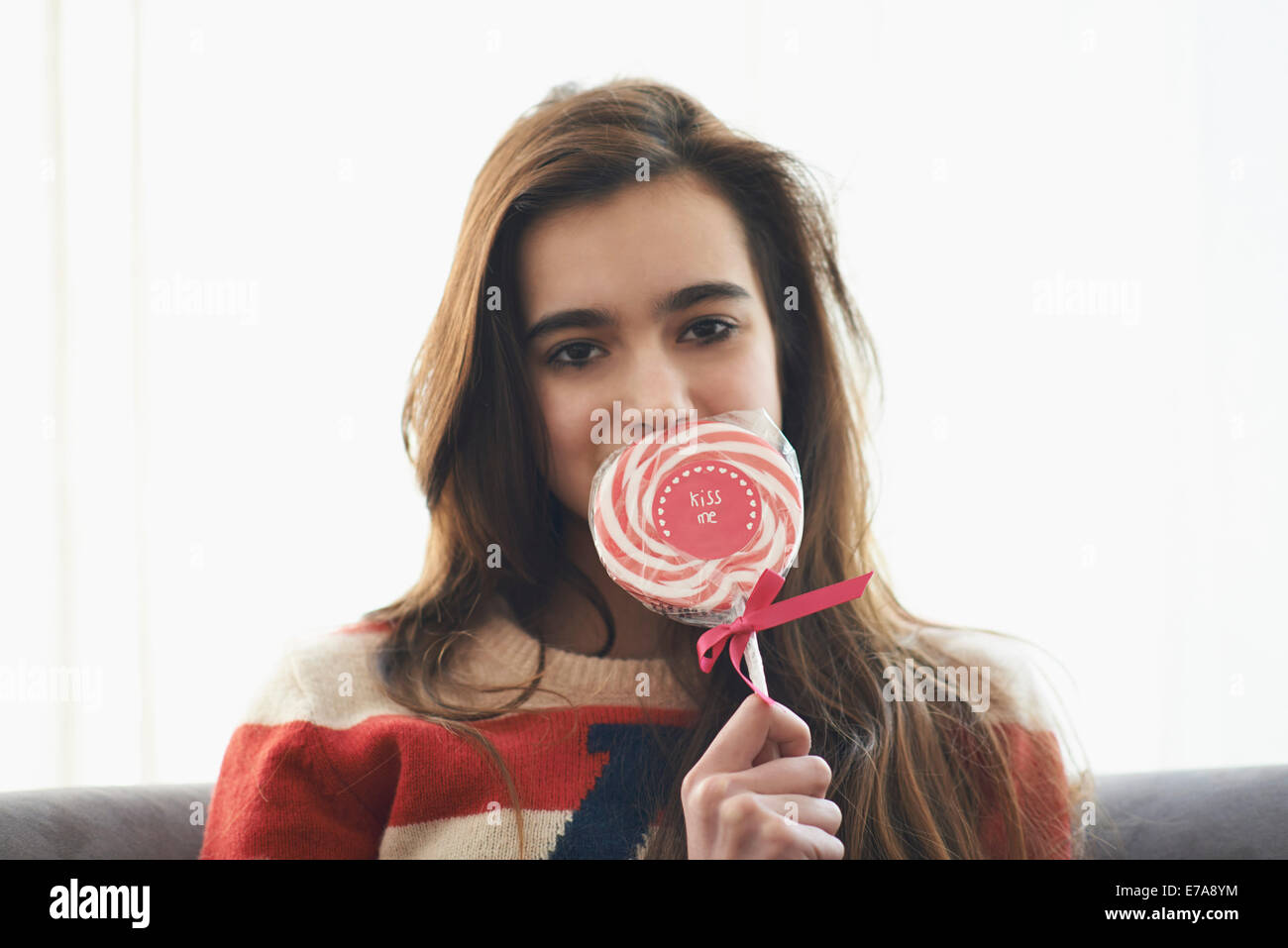 Portrait de jeune fille romantique couvrant la bouche avec une sucette à la  maison Photo Stock - Alamy