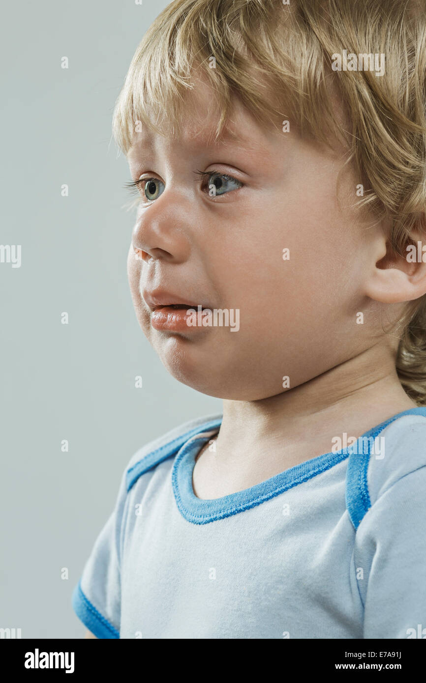 Cute boy pleurer sur fond gris Banque D'Images
