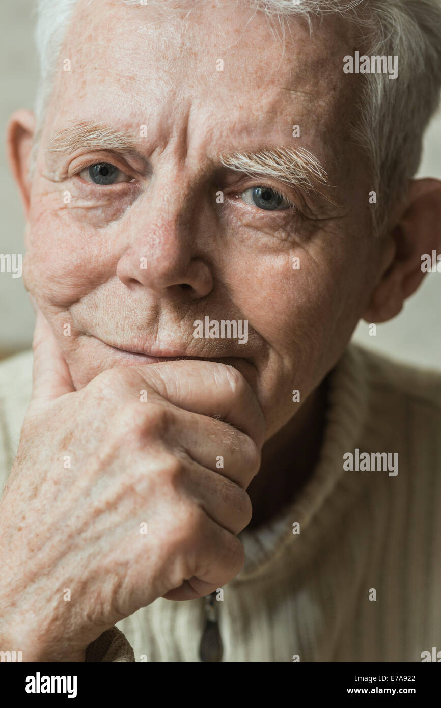 Close-up portrait of serious man with hand on chin Banque D'Images