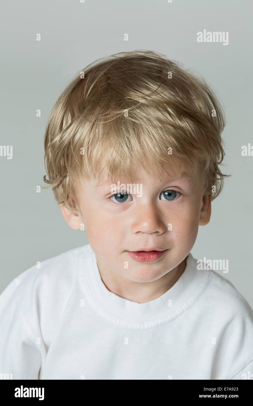 Close-up portrait of cute boy sur fond gris Banque D'Images