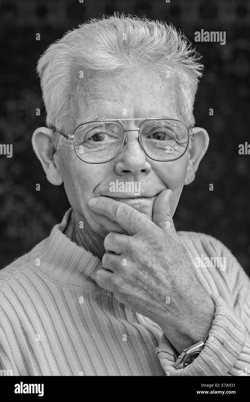 Close-up portrait of happy senior man wearing glasses sur fond noir Banque D'Images