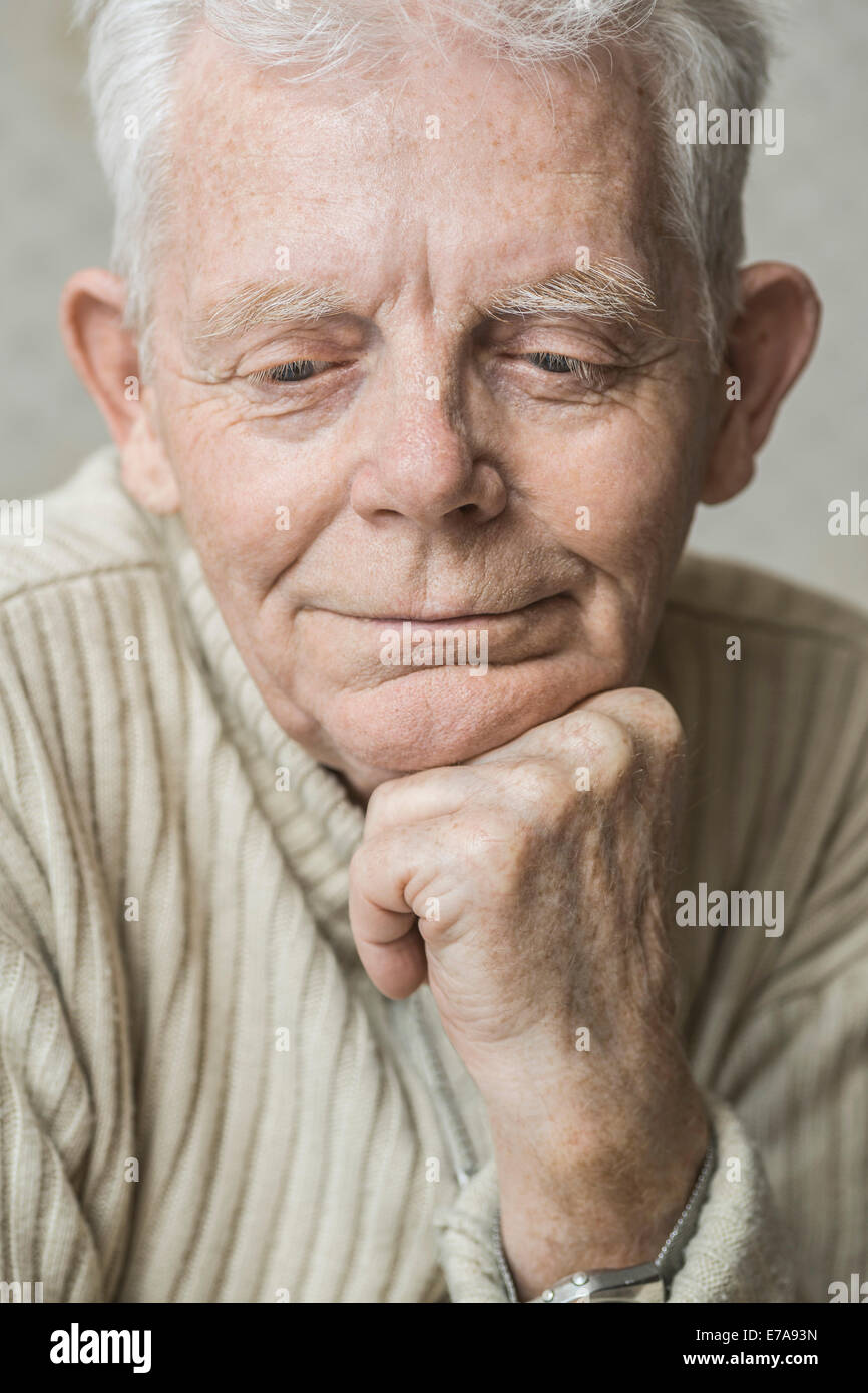 Close-up of happy man with hand on chin Banque D'Images