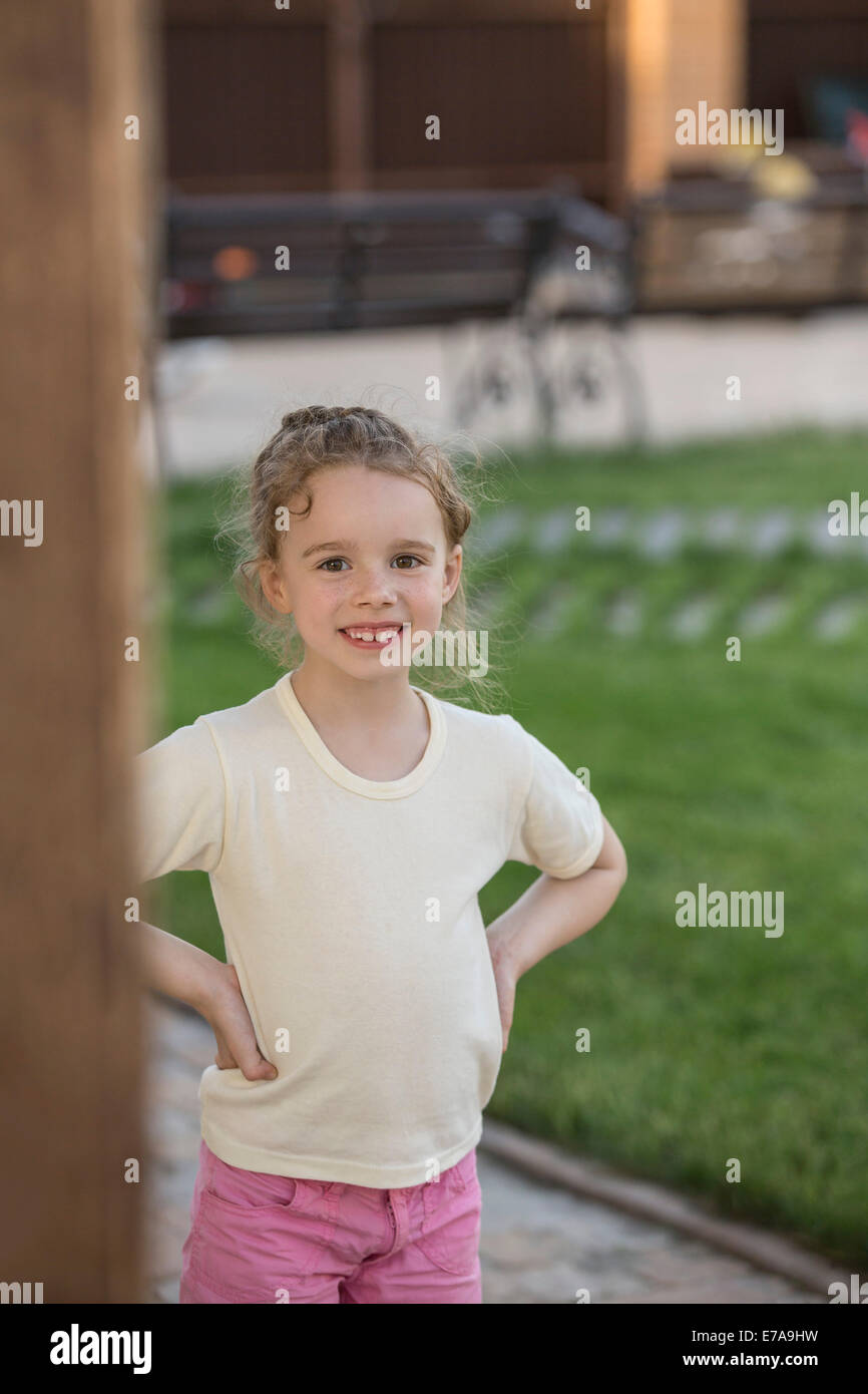 Portrait de fille mignonne avec mains sur la hanche standing in park Banque D'Images