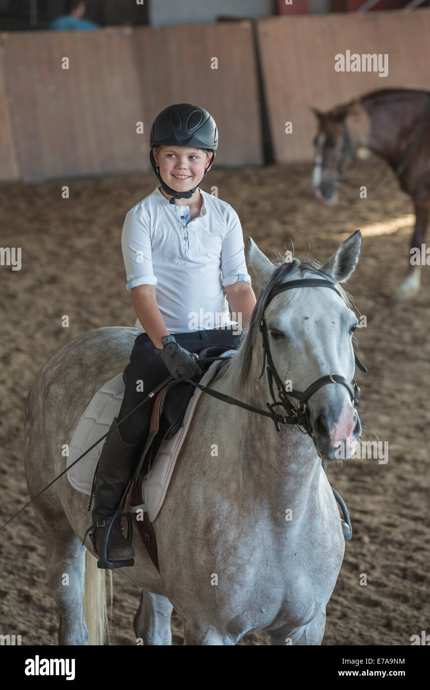 Young boy riding horse stable dans la formation Banque D'Images