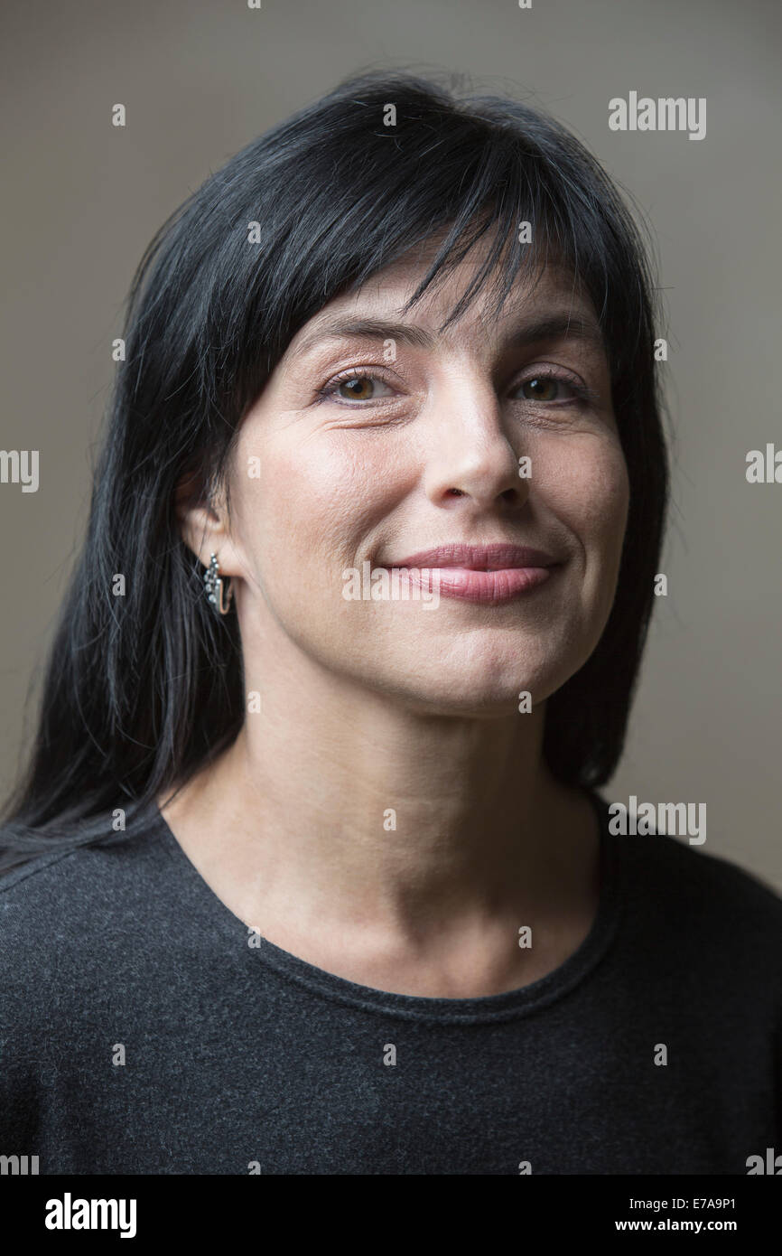 Portrait of smiling woman contre l'arrière-plan gris Banque D'Images