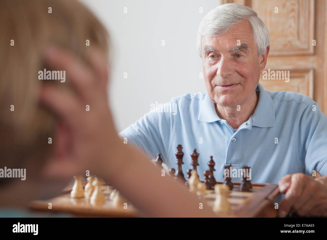 Man jouer aux échecs avec petit-fils à la maison Banque D'Images